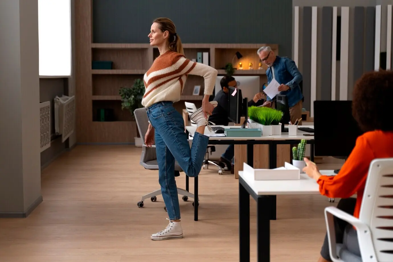 A woman stretches at the office during the workday.