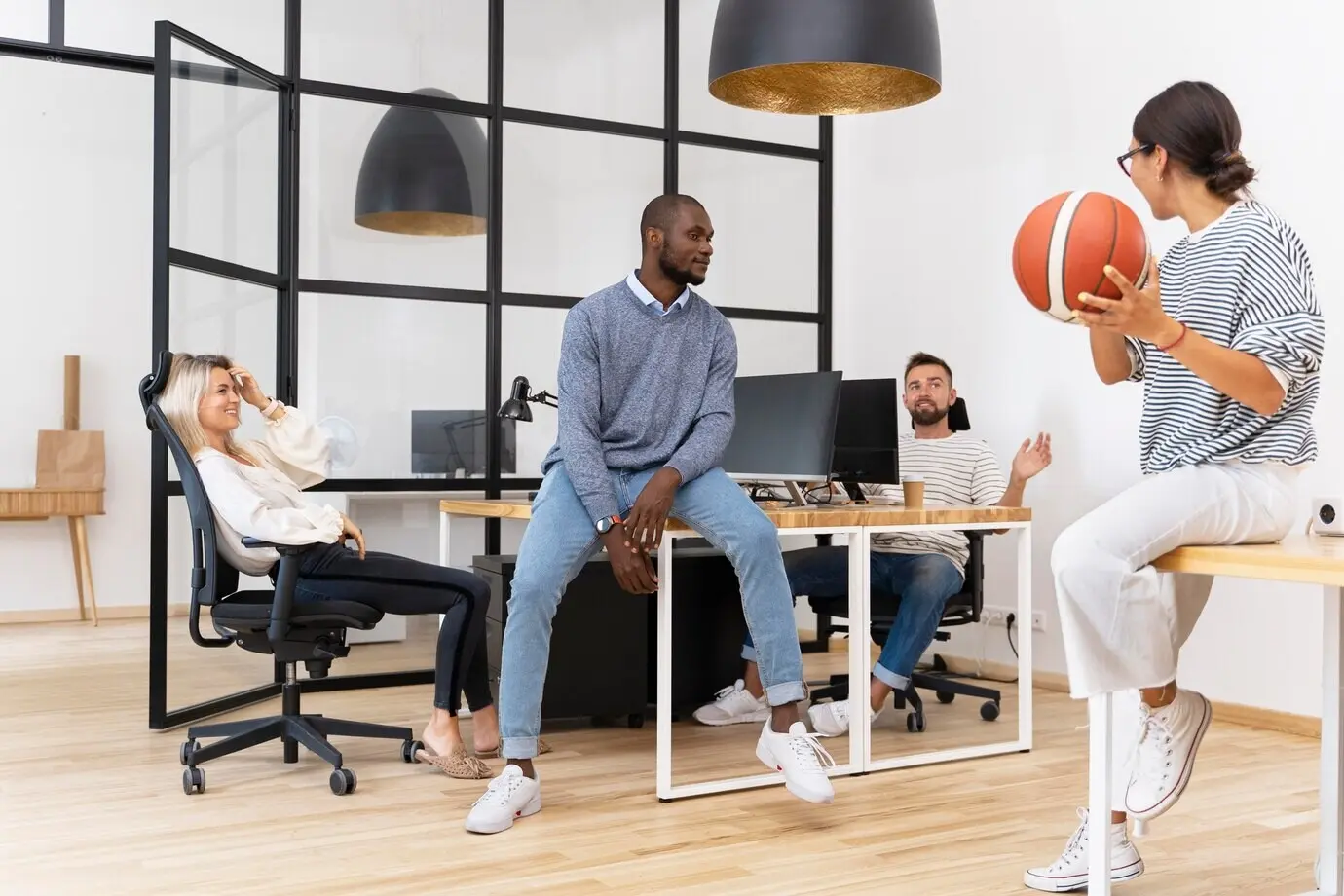 Young people playing with a ball in an office.